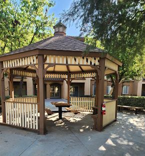 Moreno Valley apartment for rent - A gazebo with a table and chairs is surrounded by a wooden fence.