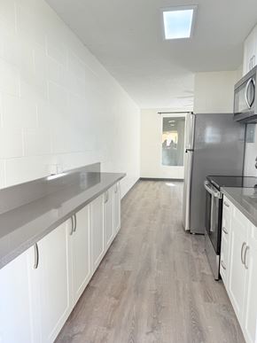 Waipahu apartment for rent - A kitchen with white cabinets and a black countertop.