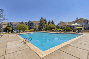 Englewood apartment for rent - A swimming pool surrounded by a concrete patio and residential houses.