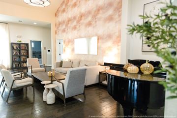 Calabasas apartment for rent - A living room with a piano, a bookshelf, and a large painting on the wall.