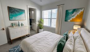 Dallas townhouse for rent - A bedroom with a large bed and a painting on the wall.