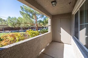 Las Vegas apartment for rent - A balcony with a door and a window overlooking a parking lot.