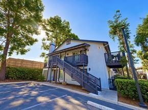 Spring Valley apartment for rent - A modern two-story house with a balcony and stairs leading to the entrance.