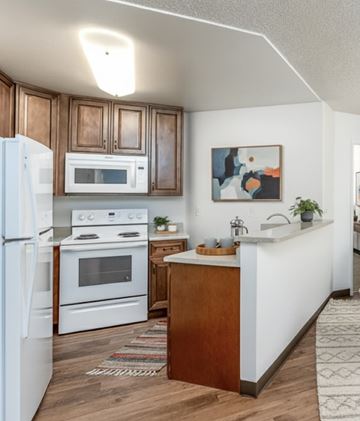 Spring Valley apartment for rent - A kitchen with white appliances and wooden cabinets.