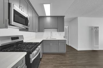 Montebello apartment for rent - A modern kitchen with a stove top oven and microwave above it.