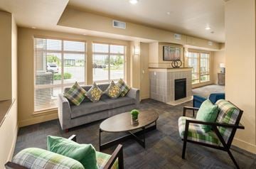 Lafayette apartment for rent - A living room with a grey couch, a green pillow, a wooden chair and a fireplace.