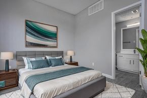 Dallas apartment for rent - a bedroom with grey walls and a white bed