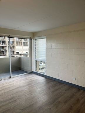 Honolulu apartment for rent - Napili Towers Bedroom with a wooden floor and a white wall with a window.