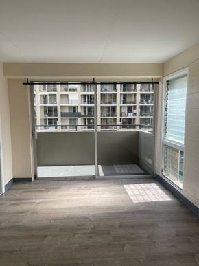 Honolulu apartment for rent - A room with a large window and a view of a building outside.