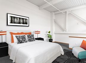 Portland apartment for rent - A bedroom with a white bed and a black and white picture on the wall.