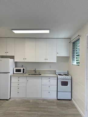 Honolulu apartment for rent - A kitchen with white appliances and cabinets.