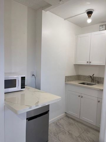 Honolulu apartment for rent - A kitchen with white cabinets and a countertop.