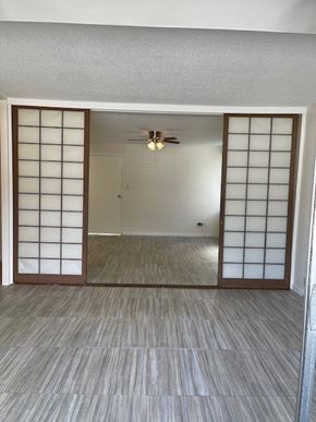 Honolulu apartment for rent - A room with a ceiling fan and sliding doors.