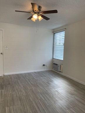 Honolulu apartment for rent - A room with a ceiling fan and a window with blinds.