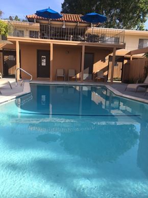 Camarillo apartment for rent - A swimming pool in front of a house with a blue umbrella.