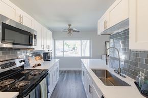 Crestwood apartment for rent - a kitchen with white cabinets and black appliances and a sink