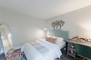 Crestwood apartment for rent - a bedroom with a white bed and a green headboard