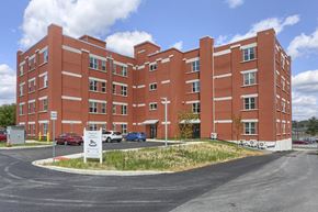 Mount Joy apartment for rent - Mount Joy Senior Housing | a large red building with a parking lot in front of it