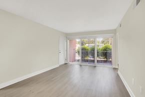 Harrisburg apartment for rent - A room with a white door and a window with a view of a fence and trees.
