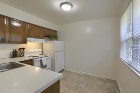 York apartment for rent - an empty kitchen with white appliances and a large window