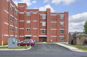 Mount Joy apartment for rent - Mount Joy Senior Housing | a large red building with a parking lot in front of it