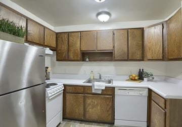 Etters apartment for rent - A kitchen with wooden cabinets and a stainless steel refrigerator.