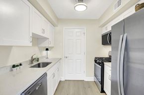 Harrisburg apartment for rent - A kitchen with white cabinets and a black fridge.