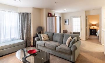 State College apartment for rent - A living room with a grey couch and a glass coffee table.