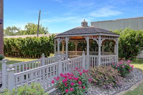 Sunbury apartment for rent - A gazebo surrounded by a white picket fence and pink flowers.