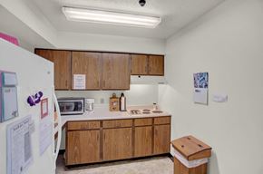 Orbisonia apartment for rent - a kitchen with wooden cabinets and a white refrigerator