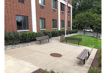 Allentown apartment for rent - A brick building with a flag on it and a green lawn in front.