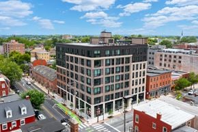 Lancaster apartment for rent - A large building with a green roof is in the middle of a city street.