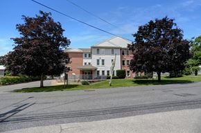 Three Springs apartment for rent - Apartments in Three Springs | Three Springs Estates |  a large brick building with a white roof and a street in front of it