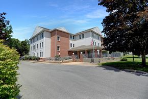 Three Springs apartment for rent - Apartments in Three Springs | Three Springs Estates | a large brick building with a gray roof and a black asphalt road in front of it