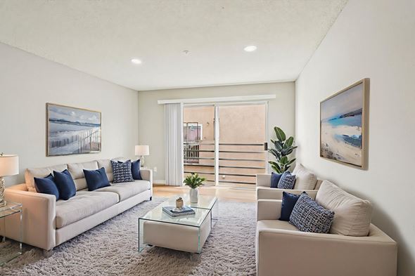 North Hollywood apartment for rent - A living room with a white couch, a glass coffee table, and a painting on the wall.