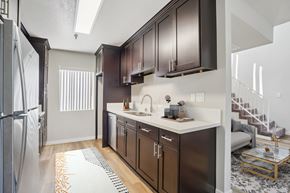Hawthorne apartment for rent - A modern kitchen with dark brown cabinets and a white countertop.