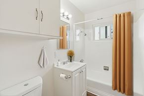 Inglewood apartment for rent - A white bathroom with a toilet, sink, and shower.