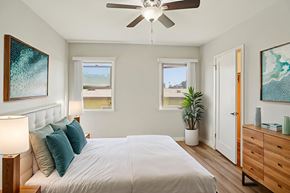 Los Angeles apartment for rent - A bedroom with a large bed, a ceiling fan, and a painting on the wall.
