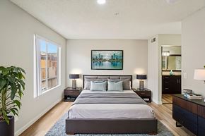 North Hollywood apartment for rent - A bedroom with a large bed and a painting on the wall.