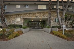 Inglewood apartment for rent - The front of a building with a stone facade and a walkway leading to the entrance.