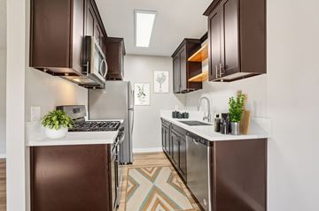 Lake Balboa apartment for rent - A kitchen with brown cabinets and a white counter.