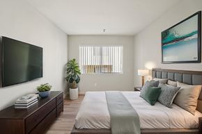 Hawthorne apartment for rent - A bedroom with a large bed and a flat screen TV mounted on the wall.