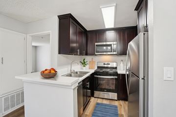 Van Nuys apartment for rent - A modern kitchen with dark brown cabinets and stainless steel appliances.