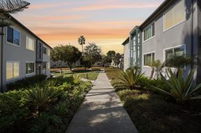 Los Angeles apartment for rent - A pathway leads through a landscaped area between two rows of buildings.