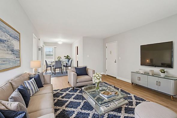 Inglewood apartment for rent - A living room with a beige couch, a glass coffee table, and a painting on the wall.