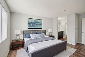 Van Nuys apartment for rent - A bedroom with a large bed and a painting on the wall.