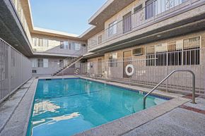 Lake Balboa apartment for rent - A swimming pool in a courtyard surrounded by buildings.