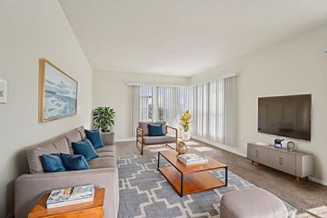 Los Angeles apartment for rent - A living room with a grey couch, a wooden coffee table, and a painting on the wall.