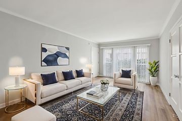 Los Angeles apartment for rent - A living room with a white sofa, a glass coffee table, and a painting on the wall.
