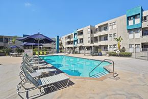 Panorama City apartment for rent - A swimming pool surrounded by sun loungers in front of apartment buildings.